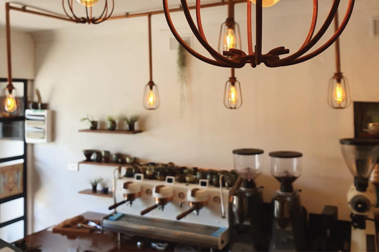 Disciple cafe location with espresso machine and coffee grinders in the background.