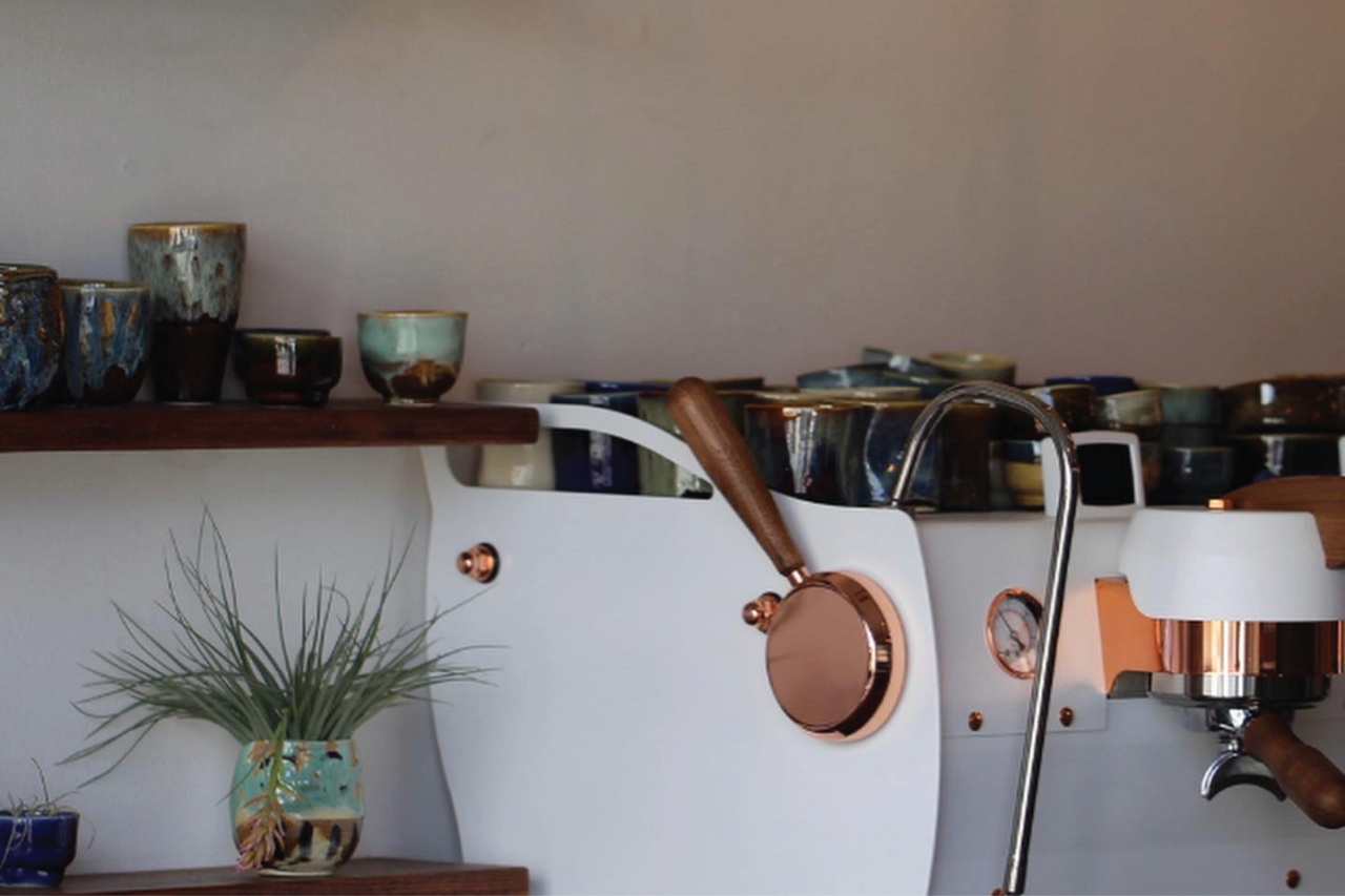 Close up of a white espresso machine at Disciple's cafe location.