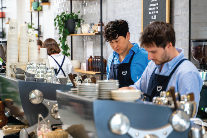 Padre Coffee baristas making coffee and serving coffee at their cafe.