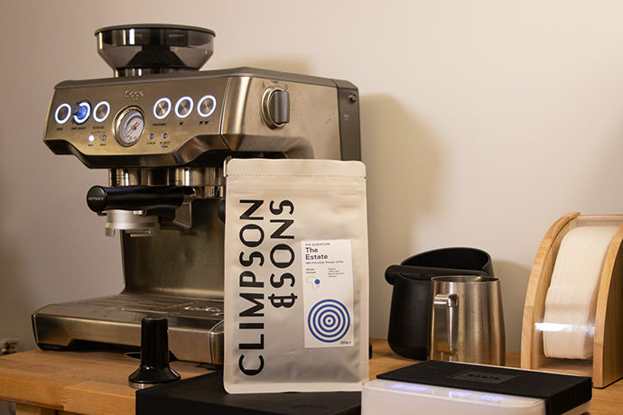 A portafilter being used in front of a Climpson & Sons coffee bag.