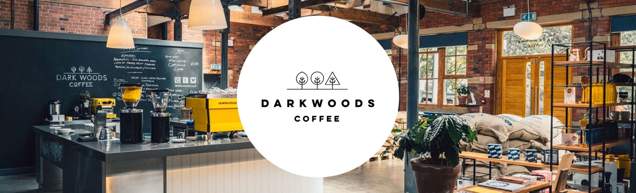 Dark Woods logo and a panorama picture of a Dark Woods roastery.