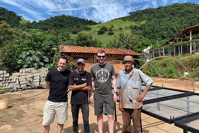 Neighbourhood staff posing with local workers at a coffee harvest site.