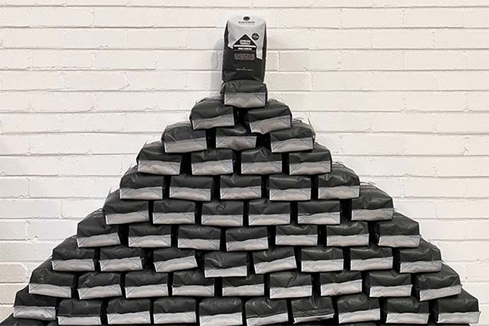 Neighbourhood coffee bags forming a piramid-shaped pile.