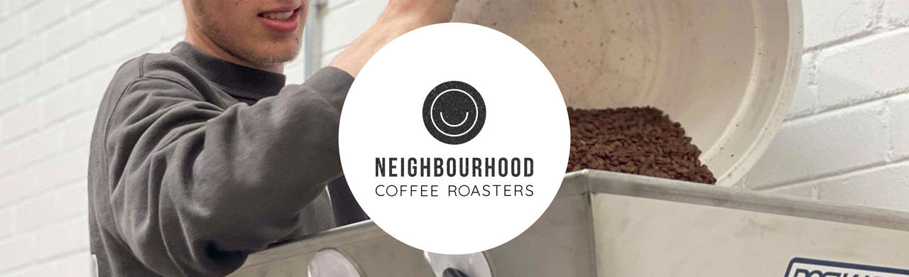 Neighbourhood logo and coffee beans being poured into a roaster machine.