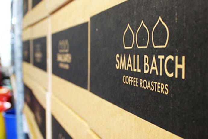 Several boxes that read 'SMALL BATCH COFFEE ROASTERS' piled on top of each other.