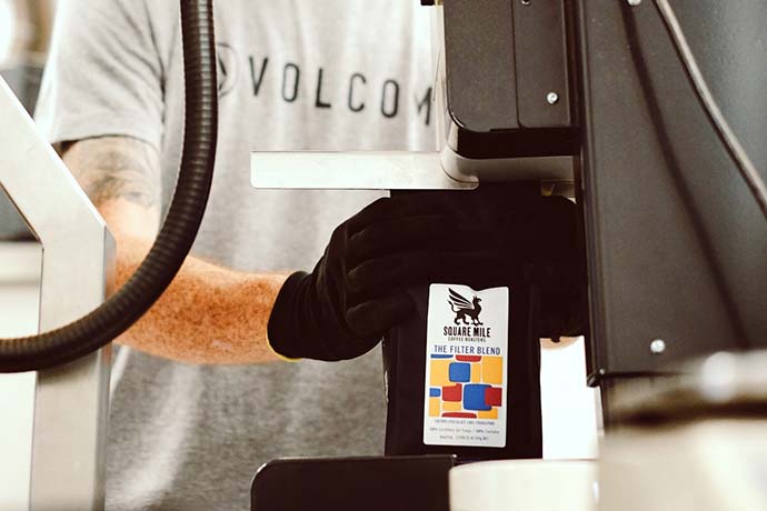 A bag of Square Mile coffee beans being sealed.