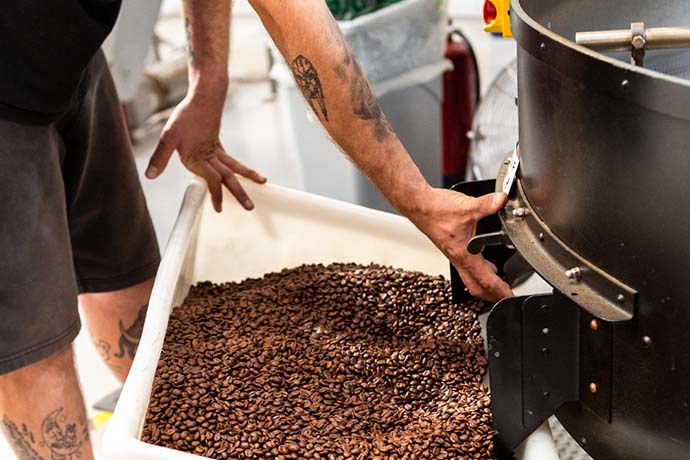 Square Mile staff regulates a coffee roasting machine.