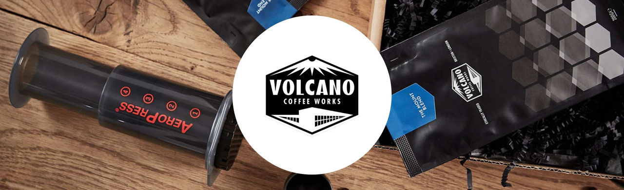 Volcano Coffee Works logo with an AeroPress tool and coffee bag in the background.