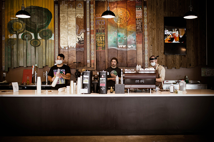 Boon Boona cafe with ornate murals and wooden backdrop featuring baristas behind the counter.