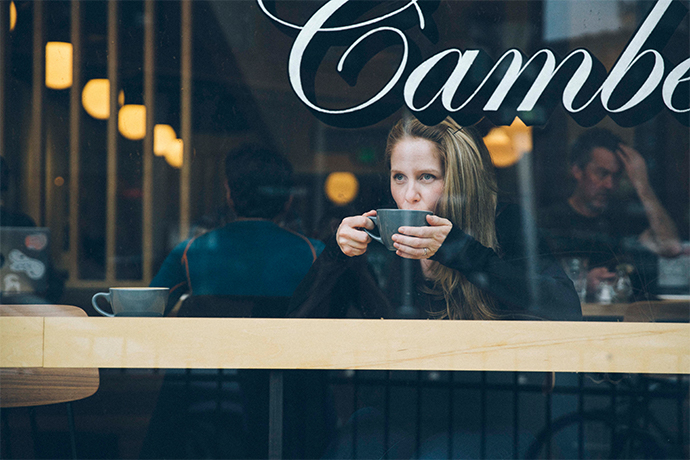 Lady drinking a beverage at a Camber cafe.