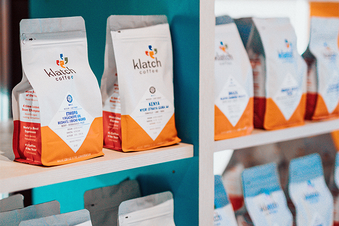 Klatch coffee bags sitting on shelves.