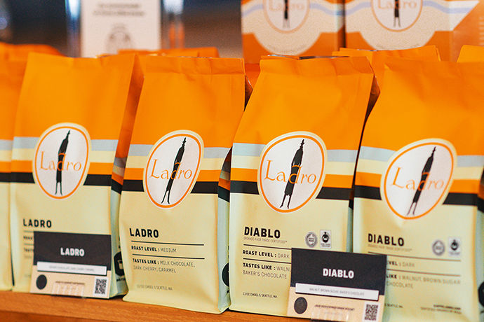 Ladro Roasting coffee bags on display with yellow packaging.