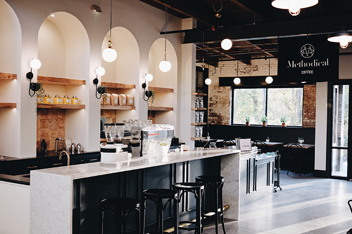 Overview shot of a Methodical cafe with modern decor and round hanging lights.