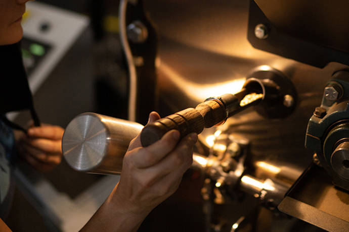 Roaster sampling roasted coffee at Olympia's roastery.