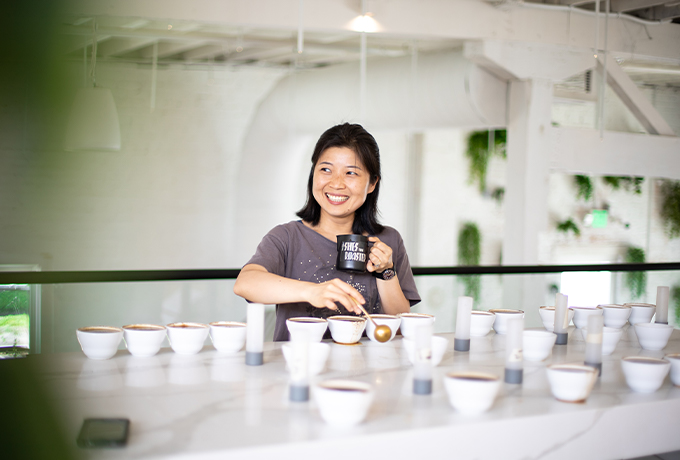 Lady cupping coffee at Onyx coffee labs with a round spoon.