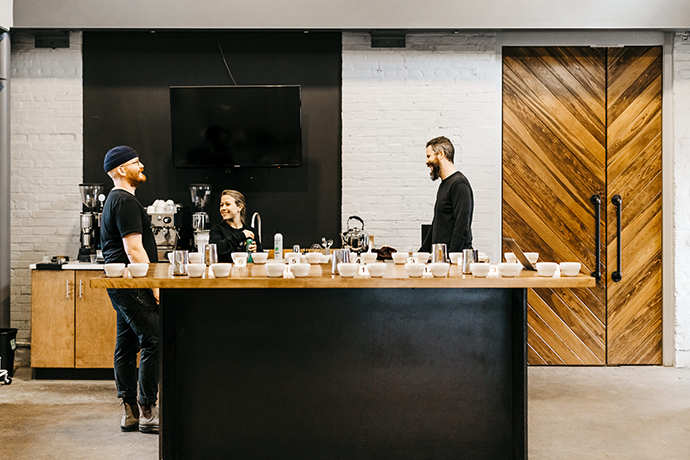Side profile of people chatting at Passenger cafe cupping room.