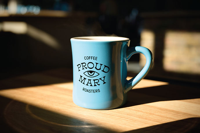 Bags of Proud Mary Coffee beans on display.
