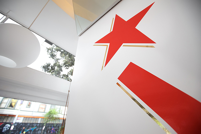 Mural of a red star and banner outside Ritual cafe location.