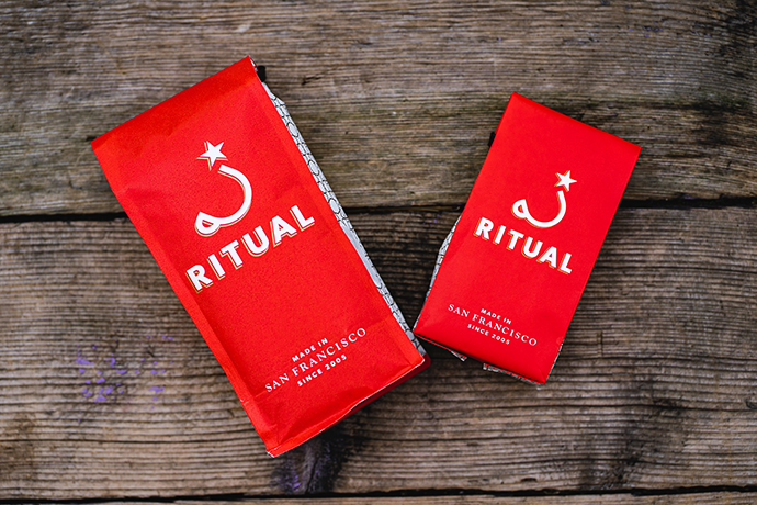 Overhead shot of Ritual coffee beans in Ritual coffee bags on a wooden table.