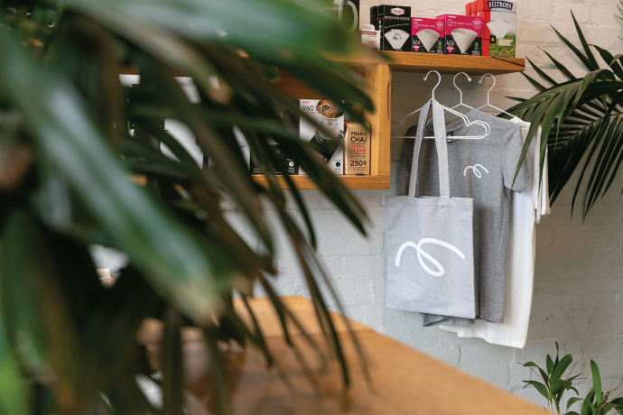 Maker cafe location with merch in background.